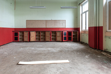 Abandoned room with open cabinet in red tones