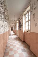 Abandoned corridor with checkerboard pattern tiles in terracotta tones