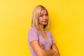 Young venezuelan woman isolated on yellow background unhappy looking in camera with sarcastic expression.