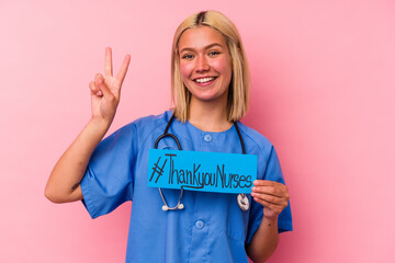 Young nurse woman holding a international nurses woman banner isolated on pink background