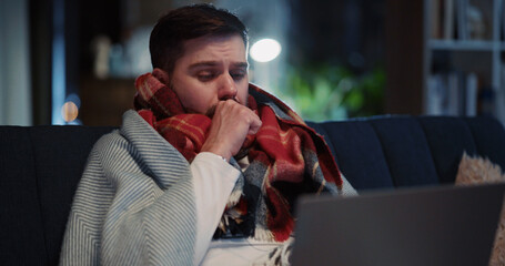 Young bearded unwell man staying at home suffering air infection disease symptoms high temperature...