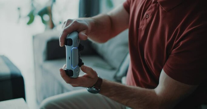 Male adult playing exciting videogames on console. Close-up shot of caucasian man holding jostick interacting virtual racing game. Entertainment.