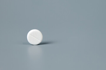 Round white pill on a gray background. High quality photo