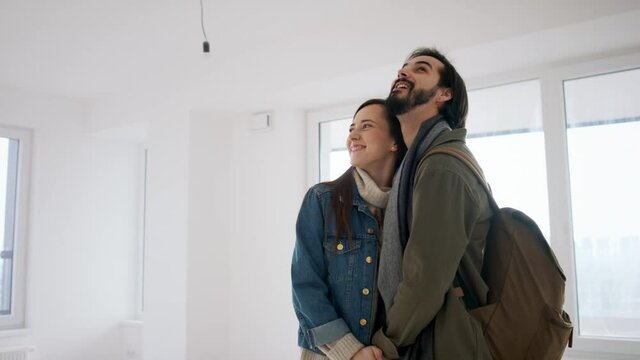 Slow motion of young couple with keys moving in new flat, new home and relocation concept.
