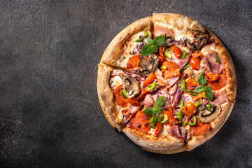 Italian pizza with bacon, pepperoni, mozzarella and mushrooms on a dark background, copy space, horizontal orientation, flat lay