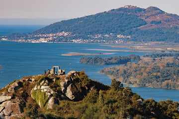 Seaside city on large hill with trees and another hill in the foreground