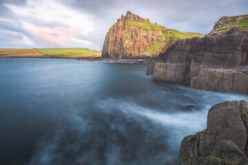 Dramatic seascape and landscape at sunset or sunrise of the historic castle ruins of Duntulm Castle on the Isle of Skye coast in the Scottish Highlands, Scotland.