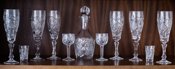 Set collection of glass goblets on the shelf, vintage glass tableware