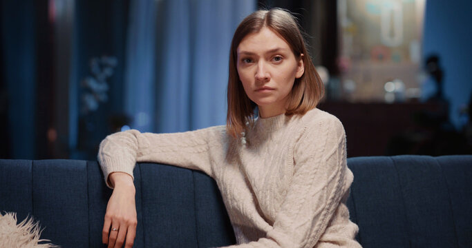 Porrait of cute beautiful young caucasian woman holdign cup with coffee resting inside apartment cozy home smiling satisfied to camera.