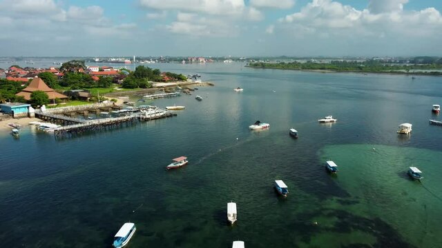 Aerial view on the beach with lot of fisherman and tourist boats in Nusa Dua beach Bali Indonesia. High quality 4k aerial footage