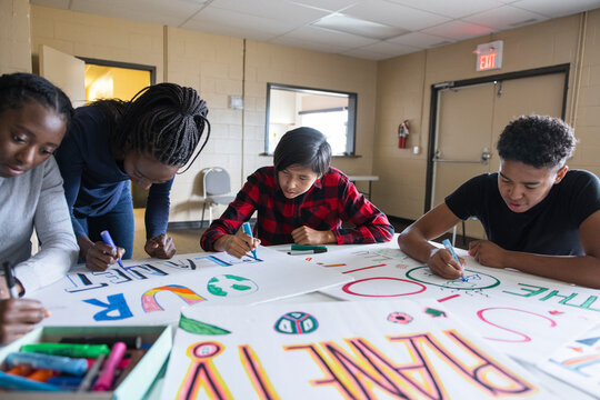 Teen environmental activists drawing posters in community center