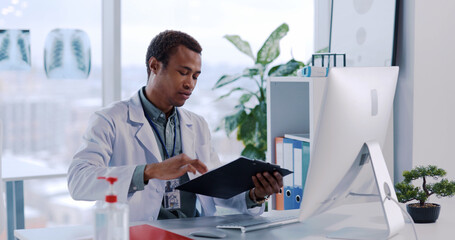 Naklejka premium African American Young Professional Doctor Talking to Patient using Computer for Remote Communication Advising Medicine and Discussing Disease.