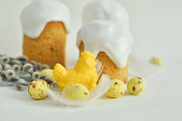 Easter sweets and decorations background. Traditional sweet cake with colorful painted eggs, chocolate hens and decor.