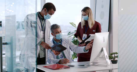 Three adult doctors in face masks collaborating in business office private clinic brainstorming diagnosis examining new disease. Social distance. Quarantine.