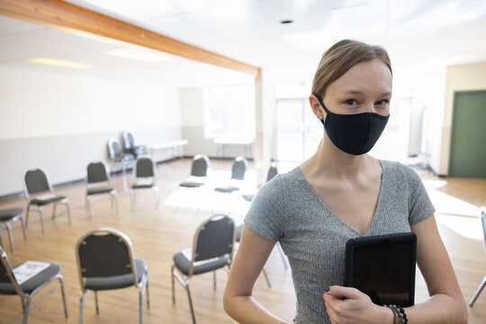 Portrait confident teen girl in face mask in community center