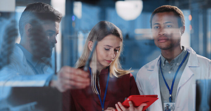 Professional multi-race medical staff with female nurse using tablet computer brainstorming sulutions for influenza coronavirus disease in modern office hospital.