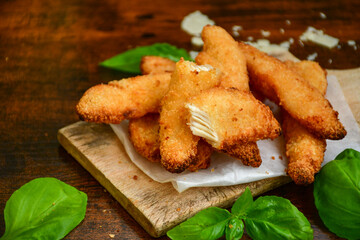 
 Crispy  deep fried home made    chicken strips Breaded  with  almond flour chicken  breast fillets  with chilly peppers and fresh   basil on wooden rustic background. Ketogenic diet food