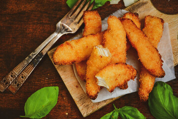 
 Crispy  deep fried home made    chicken strips Breaded  with  almond flour chicken  breast fillets  with chilly peppers and fresh   basil on wooden rustic background. Ketogenic diet food