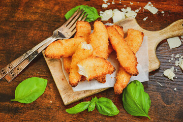 
 Crispy  deep fried home made    chicken strips Breaded  with  almond flour chicken  breast fillets  with chilly peppers and fresh   basil on wooden rustic background. Ketogenic diet food