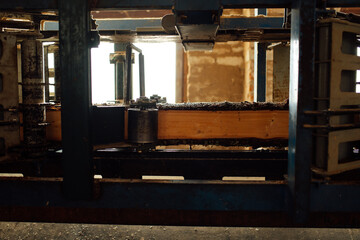wooden board on the conveyor. people work on an automated sawmill. industrial enterprise for wood processing. a worker carries a board for sawing