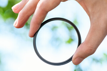 Hand hold  safety filter  for the lens against blue sky. Light background