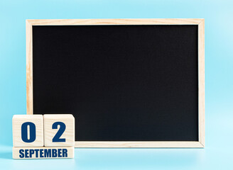 September 2. Day 2 of month, Cube calendar with date, empty frame on light blue background. Place for your text. Autumn month, day of the year concept