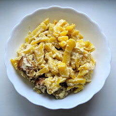 Potatoes with fish in a white plate on a light background