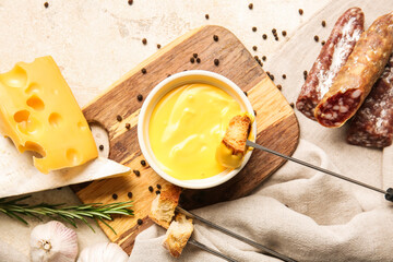 Cheese fondue and different snacks on light background