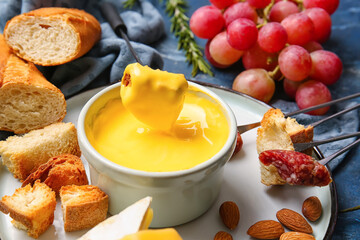 Cheese fondue and different snacks on color background