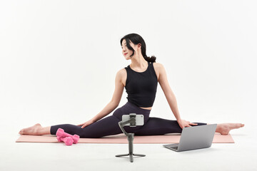 Fototapeta premium Asia Korean Girl training at white background , watching videos on laptop, and live streaming using gimbal in sns