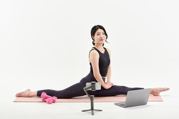 Fototapeta premium Asia Korean Girl training at white background , watching videos on laptop, and live streaming using gimbal in sns