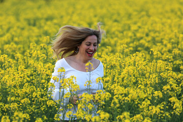Naklejka na ściany i meble woman portrait with yellow flowers field background