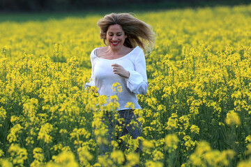 Naklejka na ściany i meble woman portrait with yellow flowers field background