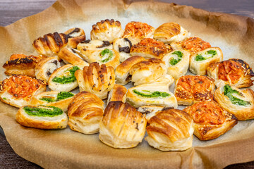 Homemade baking concept, mini pizza rolls, puff pastry rolls snacks with cheese and with black and green olives