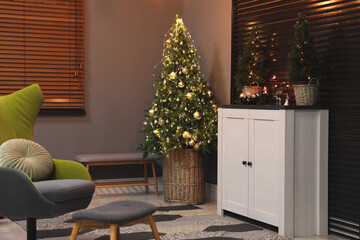 Beautiful room interior with decorated Christmas tree and white cabinet