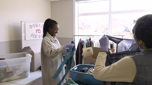 Volunteers Sorting Clothing Donations In Community Center