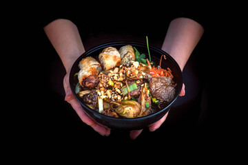 Bò bún dans un bol noir dans un restaurant asiatique