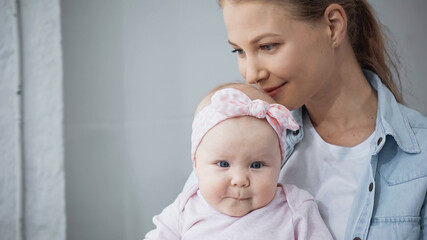 happy mother smelling hair of infant daughter.