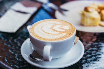 Cappuccino. A cup of cappuccino with froth is on the table.