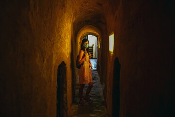 Tunnel. A woman in a medical mask walks through a dark tunnel.