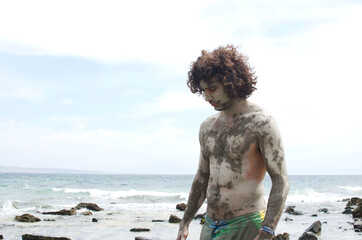 man covered in mud standing