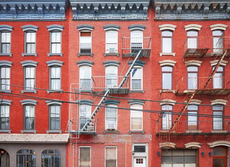 Old red brick buildings with blue iron fire escapes, New York City, USA.