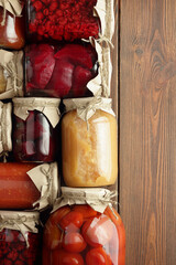 Assortment of canned vegetables and fruits- food in plastic free jars on wooden rustic table, flat lay, from above overhead top view, canned produce, saving leftovers food storage organization concept