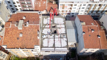 Aerial view of the building construction at the city center. Workers are pouring concrete to the...