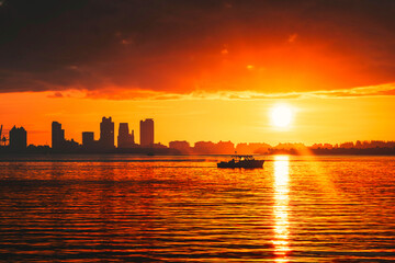 Fototapeta na wymiar sunset sea boat sun sky clouds beautiful panorama horizon buildings summer 