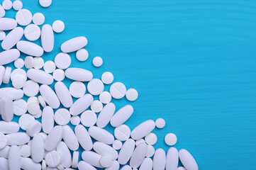 Heap of pills on blue
