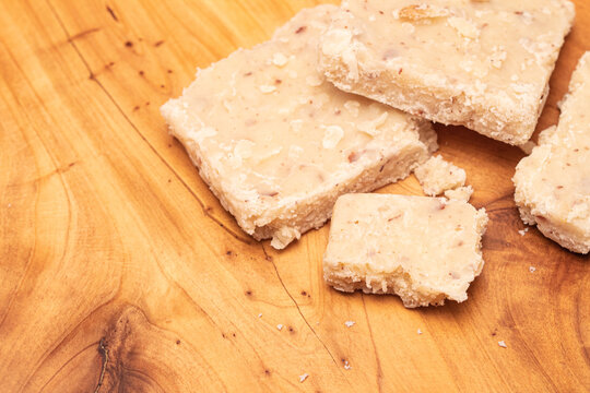 Cocada branca, doce brasileiro. Peda&ccedil;os do doce de cocada branca de corte sobre t&aacute;bua de madeira. Doce muito tradicional no Brasil. Doce feito com coco ralado, &aacute;gua ou leite e a&ccedil;&uacute;car.