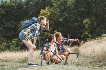 Fototapeta premium Mother hiking with her two daughter.They walking trough forest ,looking around and joying in view. 