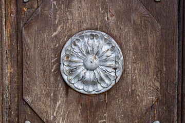 wooden surface with a round bas-relief of silver color