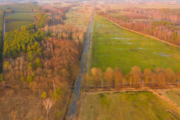 Asfaltowa droga przebiegająca przez rozległą równinę. Widok z drona.